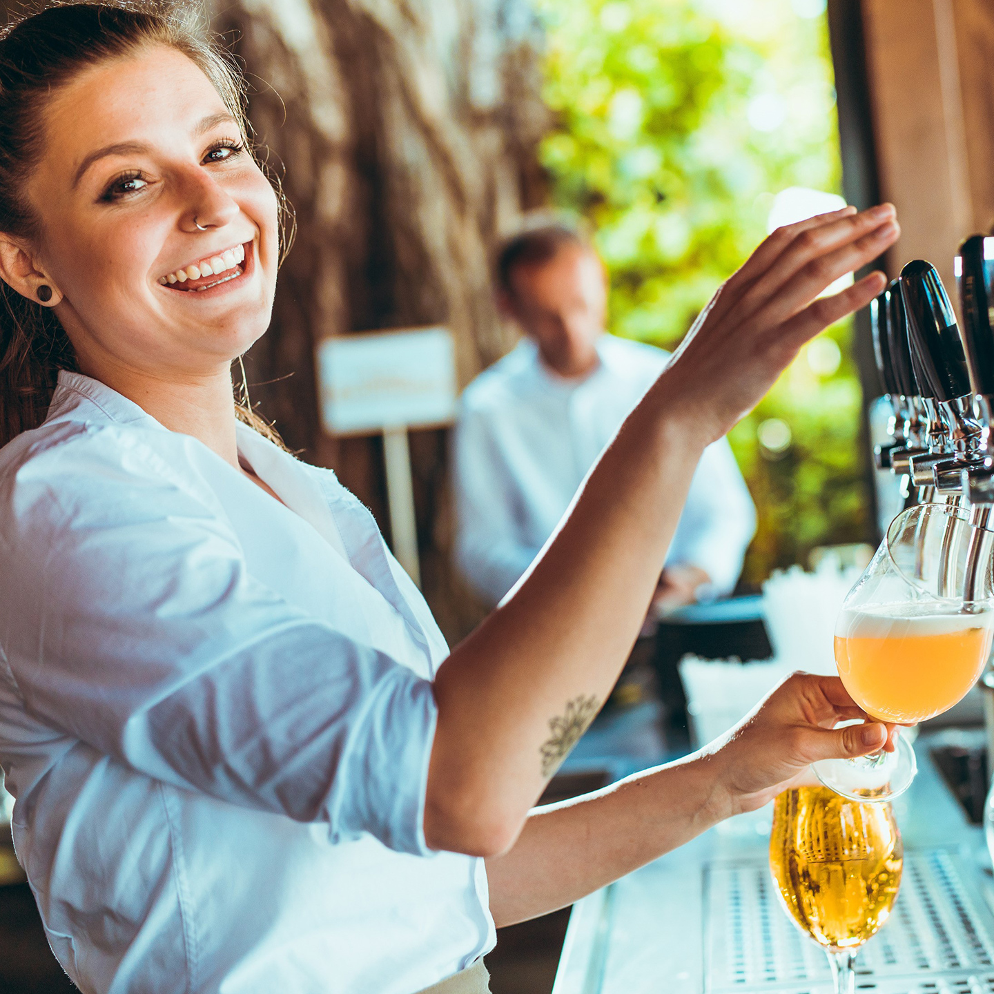 Waitress pouring beer at the Alte Kaisermühle in Vienna next to the Alte Donau