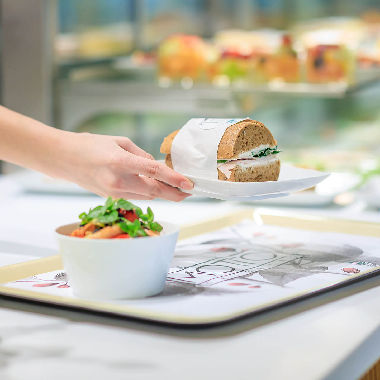 Foto: Motto Catering Mitarbeiter stellt Essen auf ein Tablet im Austria Center Vienna