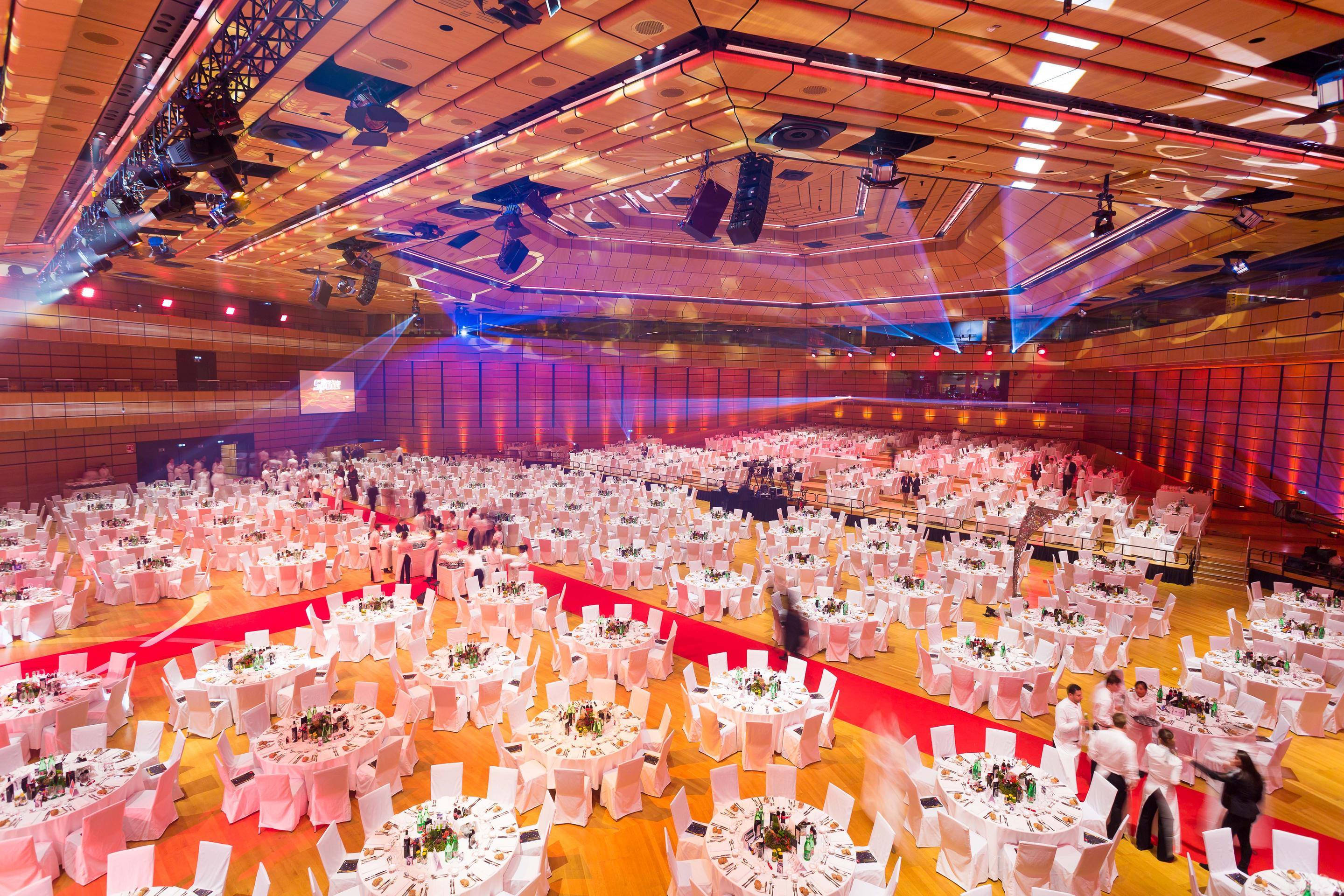 Foto: Halle mit weißen Gala-Tischen, roter Teppich