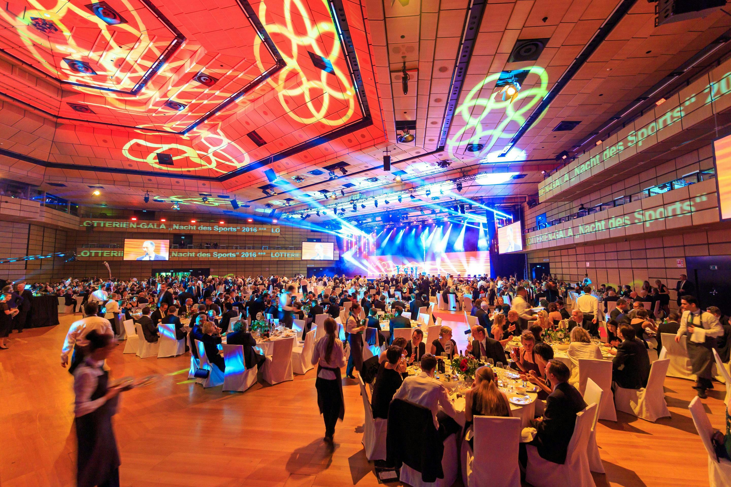 Foto: Menschen in einer Halle vor einer Buehne, Gala-Bestuhlung