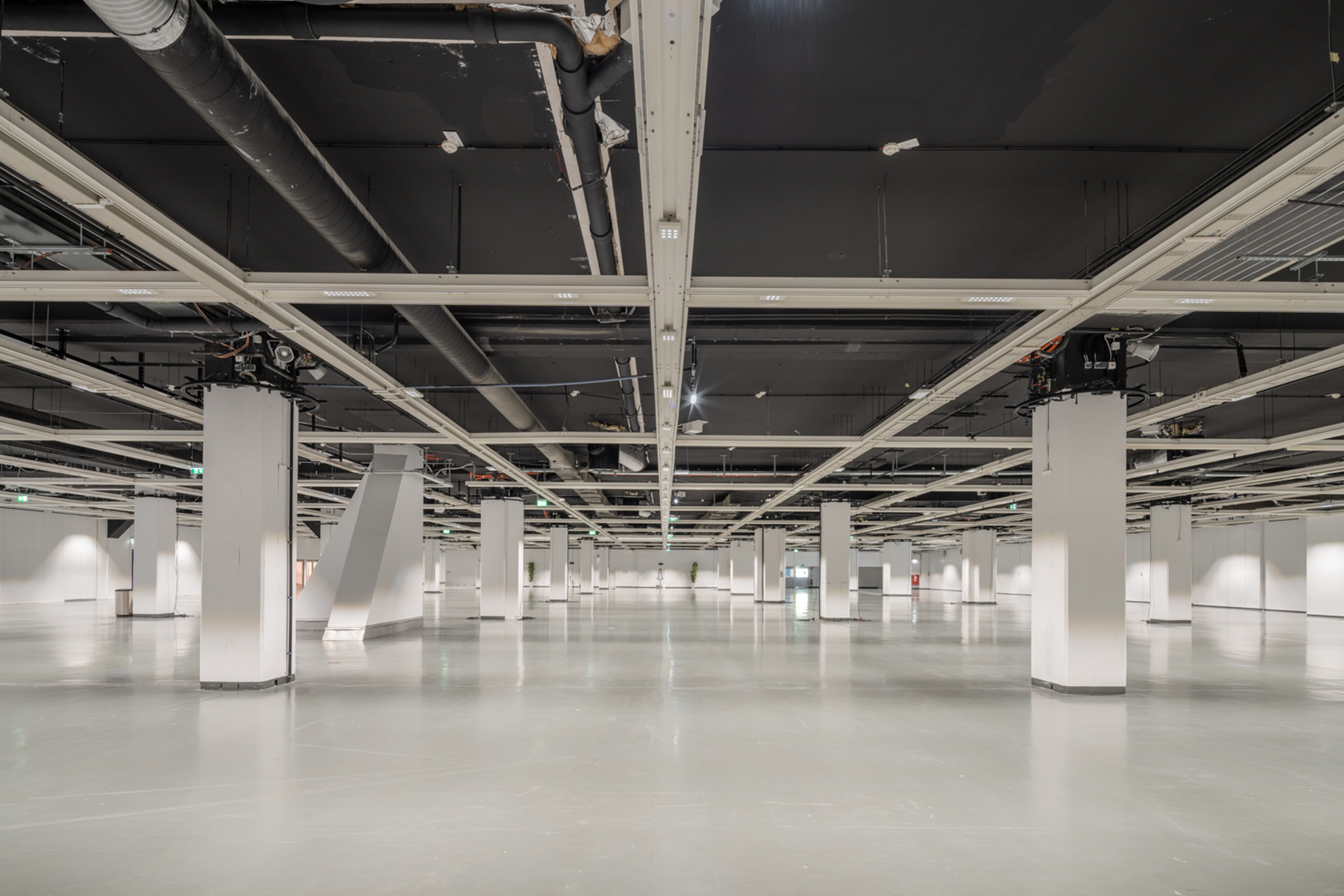 Foto: Halle mit hellem Boden und Saeulen und dunkler Decke