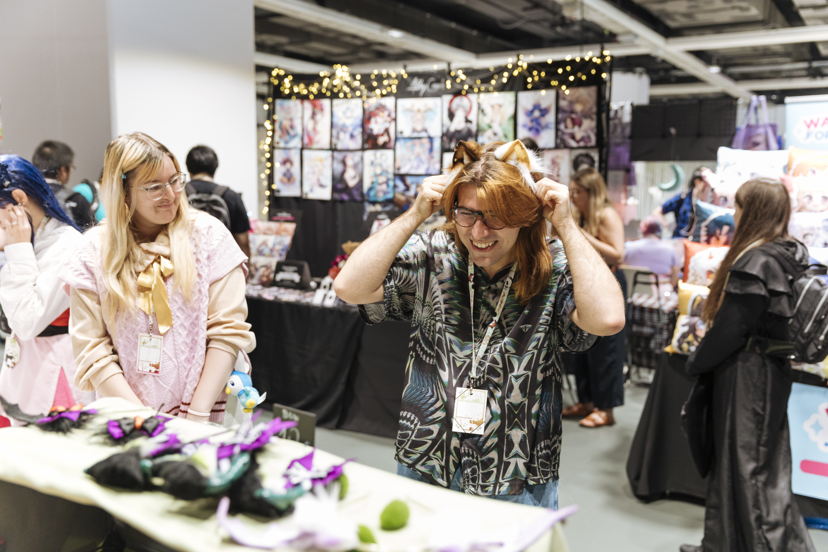 Foto: eine Frau und ein Mann probieren Haarreifen an einem Manga-Stand