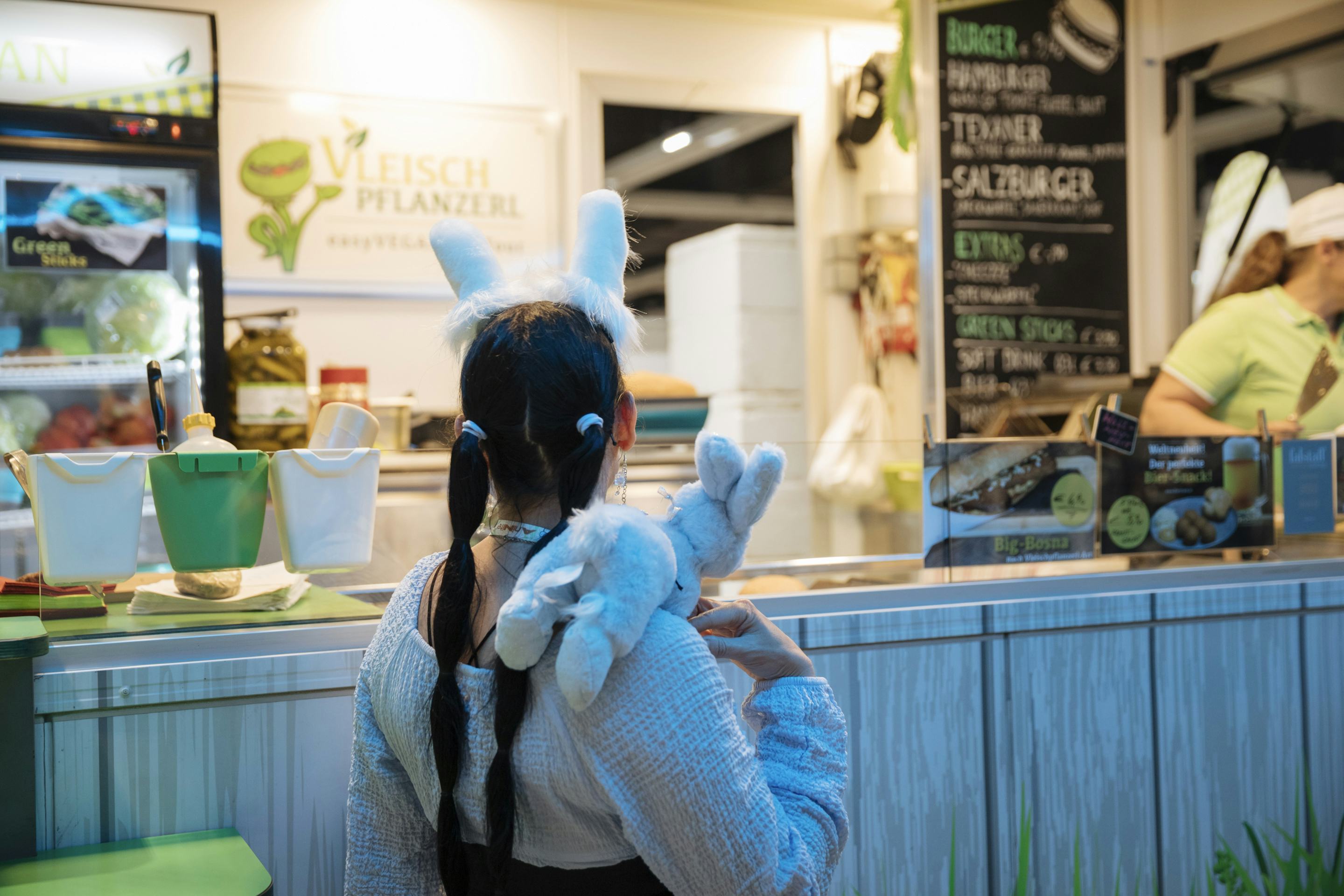 Foto: Maedchen mit Haarreifen steht vor einem Foodtruck
