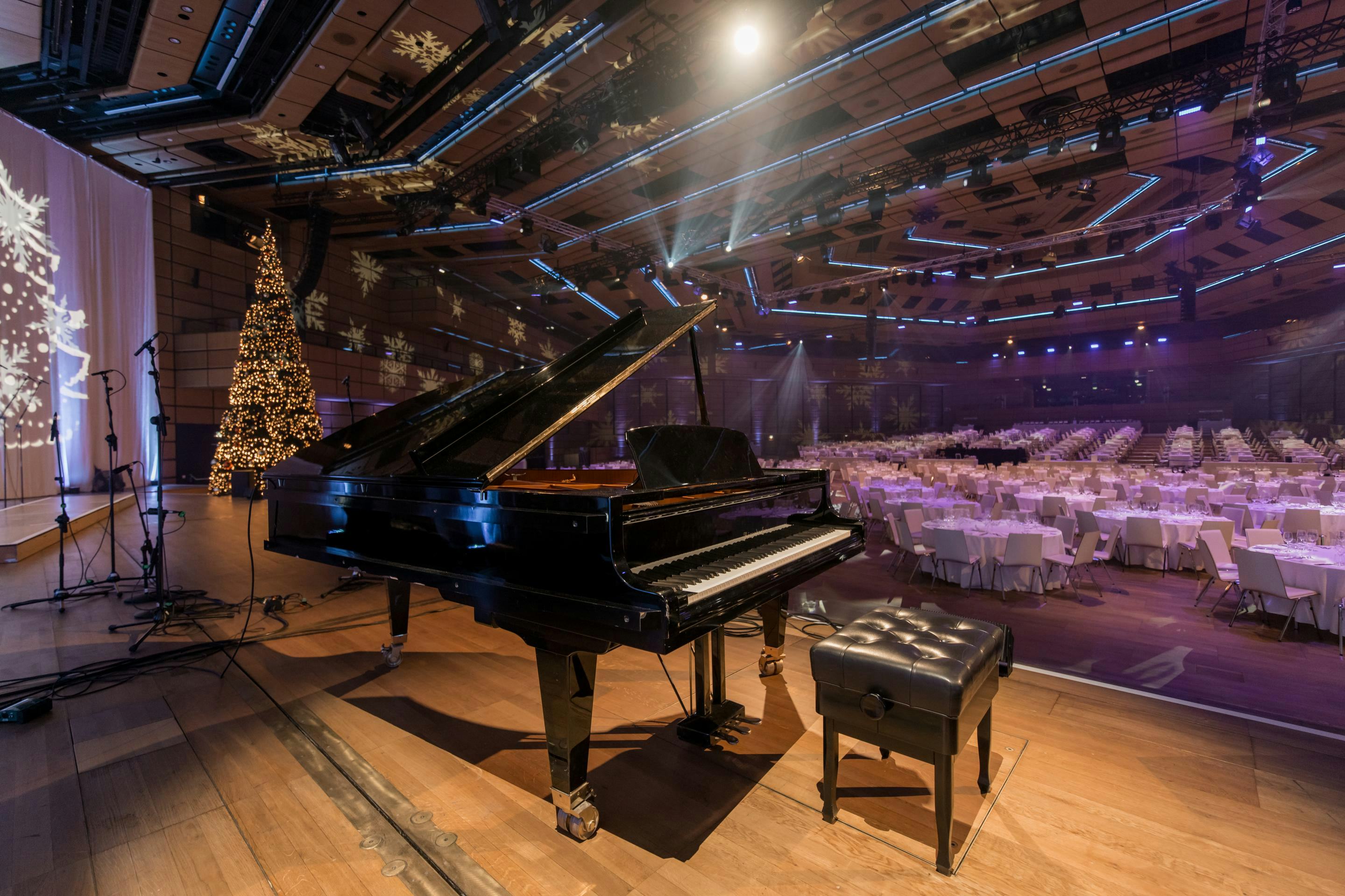 Foto: weihnachtlich dekorierte Halle mit einer Buehne und Klavierflügel