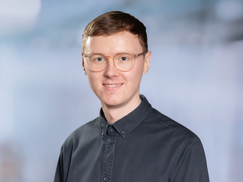 Portraitfoto eines jungen Mannes mit Brille