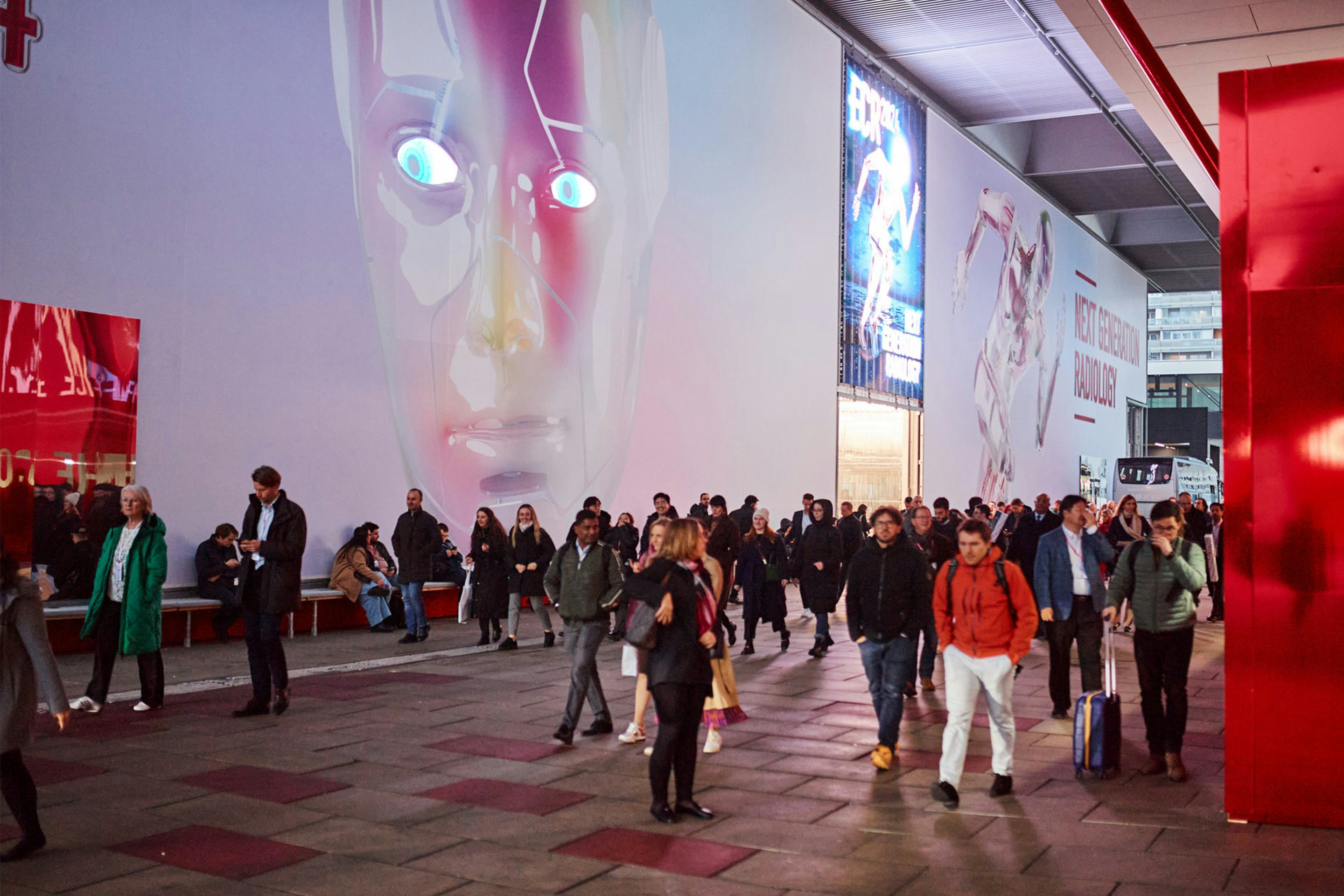 Foto: Eingang mit Roboterkopf auf einem LED Screen und vielen Menschen