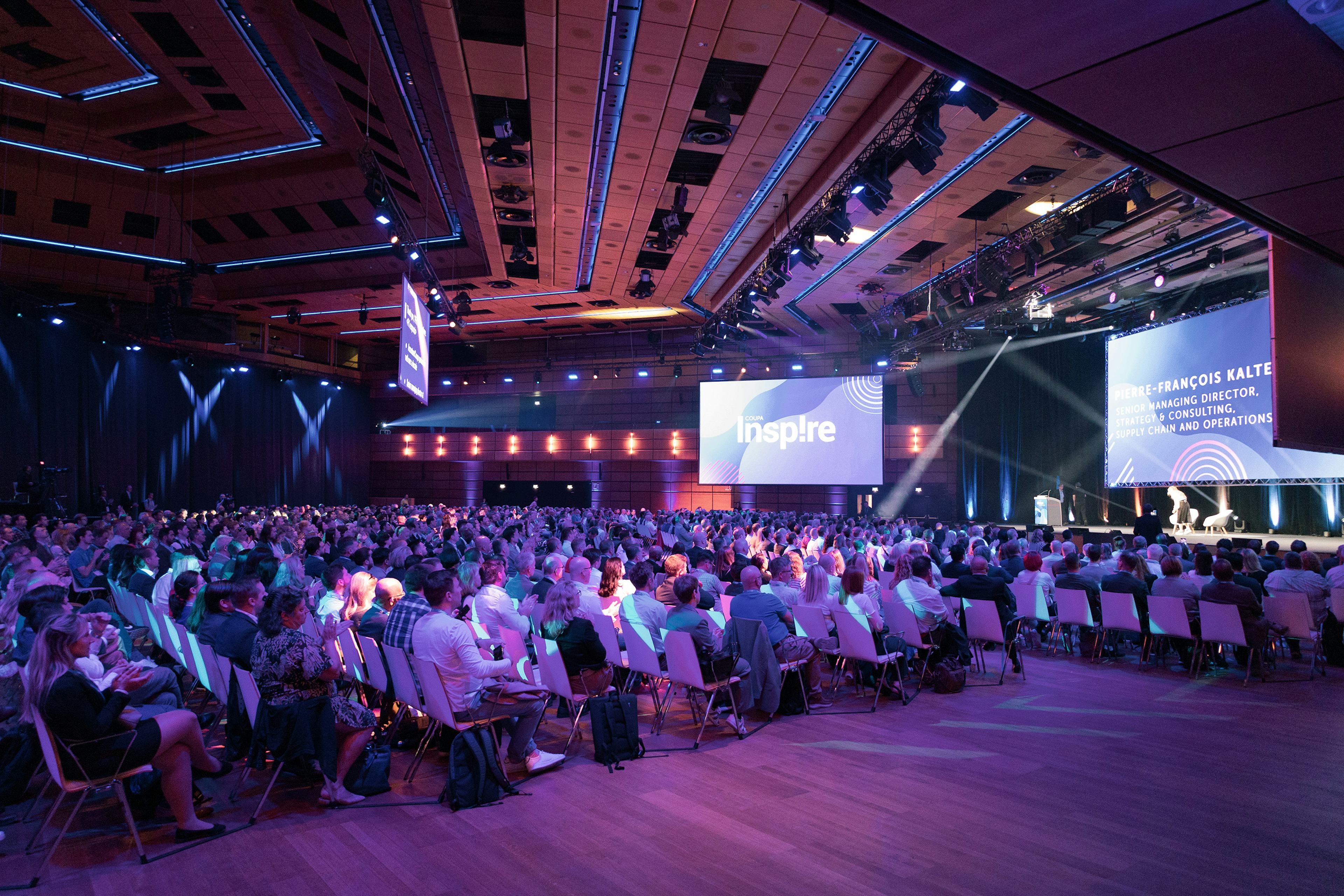 Sitzreihen voll Menschen blicken auf die Buehne von Saal A bei einem Corporate Event im Austria Center Vienna.